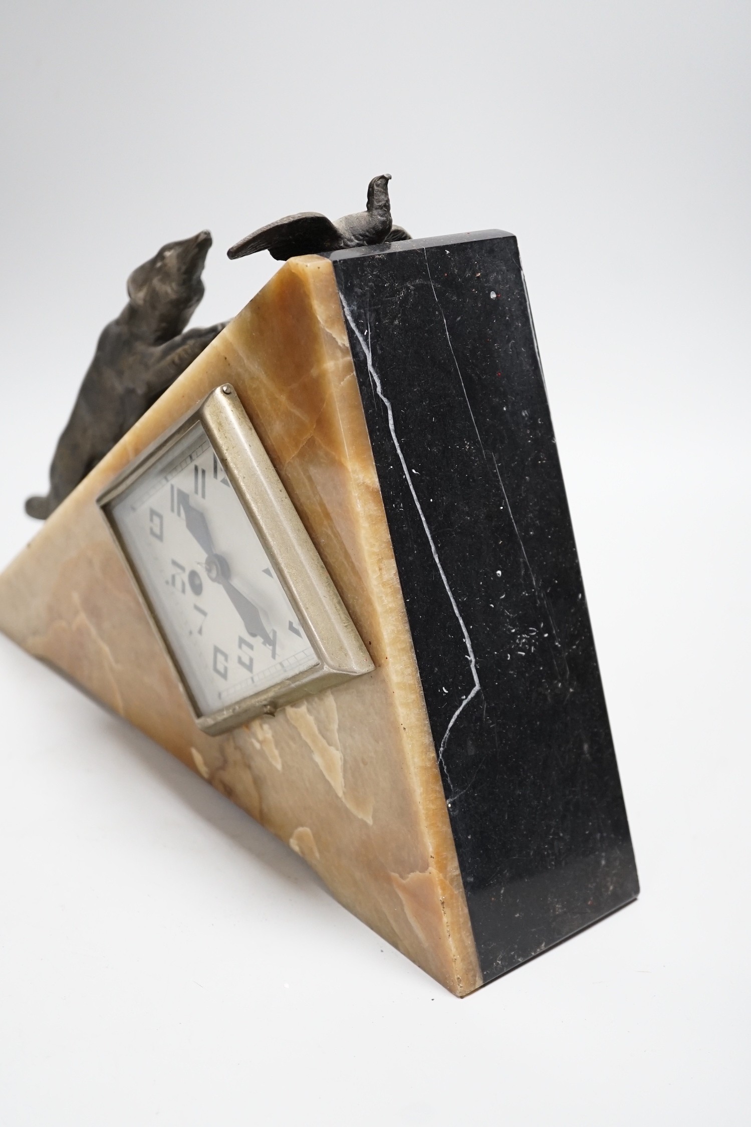 An Art Deco triangular marble and spelter clock, mounted with a fox chasing a bird, 39cms wide